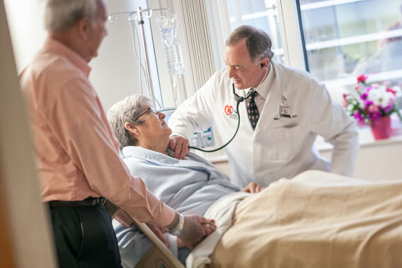 Doctor providing bedside care, emphasizing compassion and patient-focused treatment.