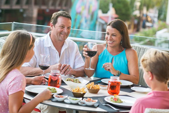 Family enjoying an outdoor dining experience, highlighting connection and hospitality atmosphere.